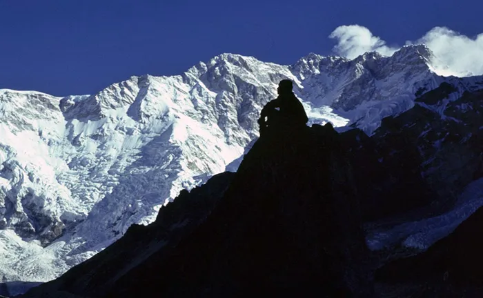 A porter crosses a makeshift bridge over a tributary of the Buri Gandaki